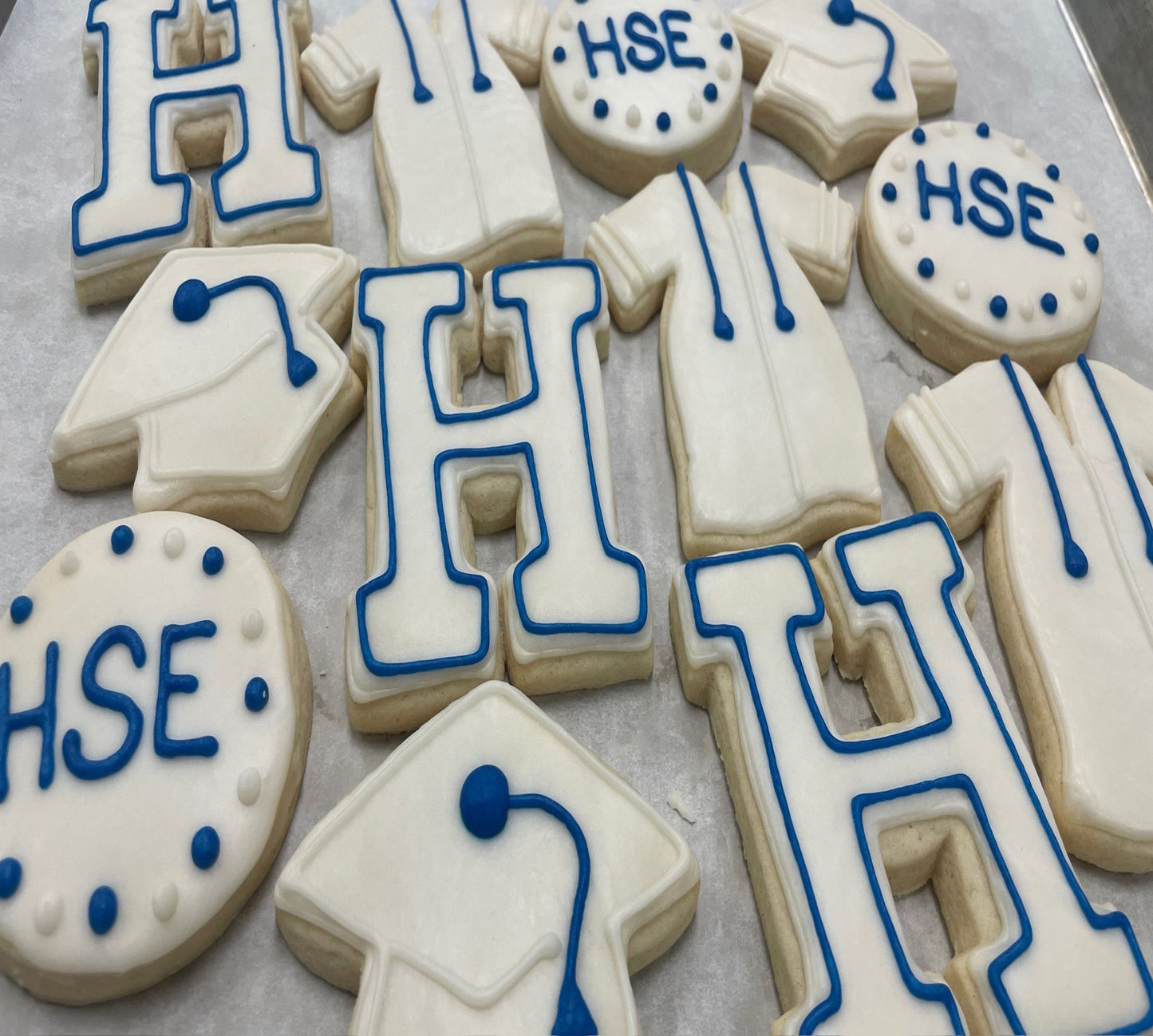 Decorative cookies with 'HSE' letters and medical symbols on a tray
